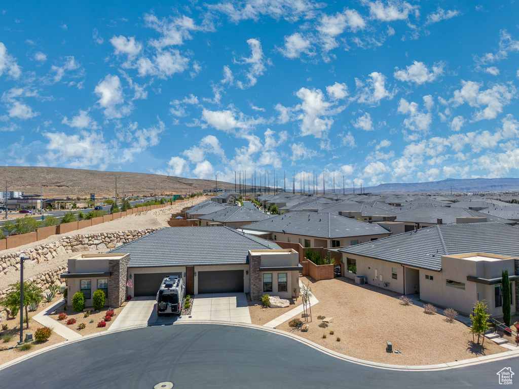 View of front of property featuring an attached garage, driveway, and a residential view