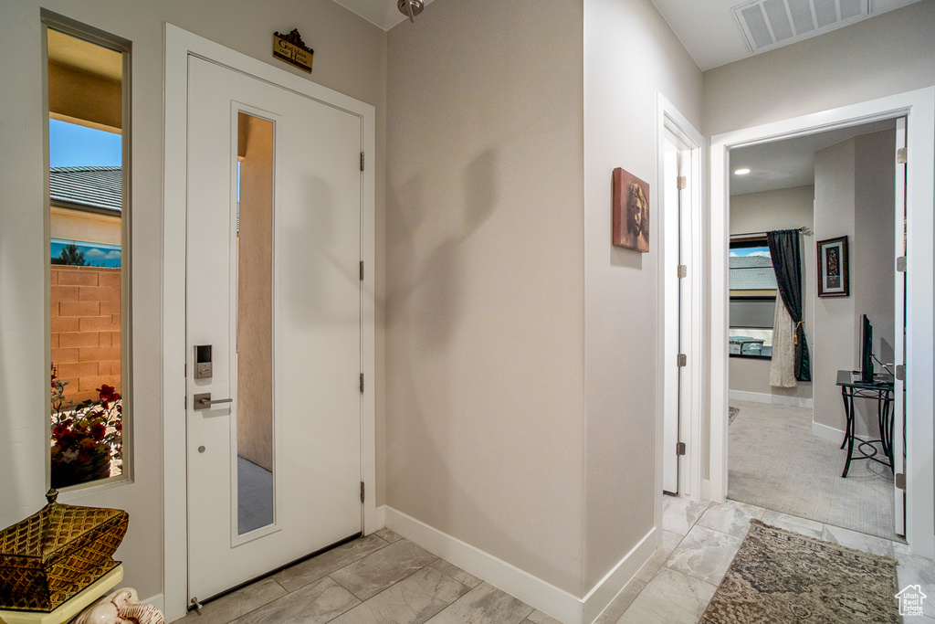 Hall featuring baseboards, marble finish floor, and visible vents