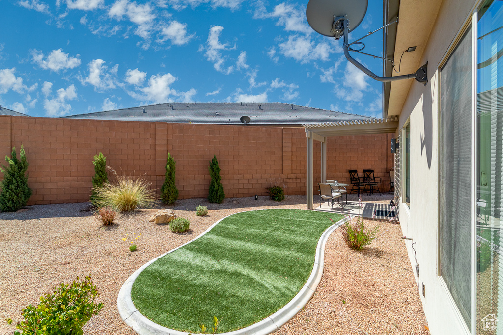View of yard with a fenced backyard and a patio