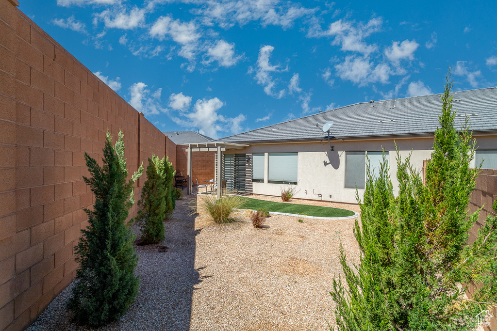 Rear view of house featuring a fenced backyard and stucco siding