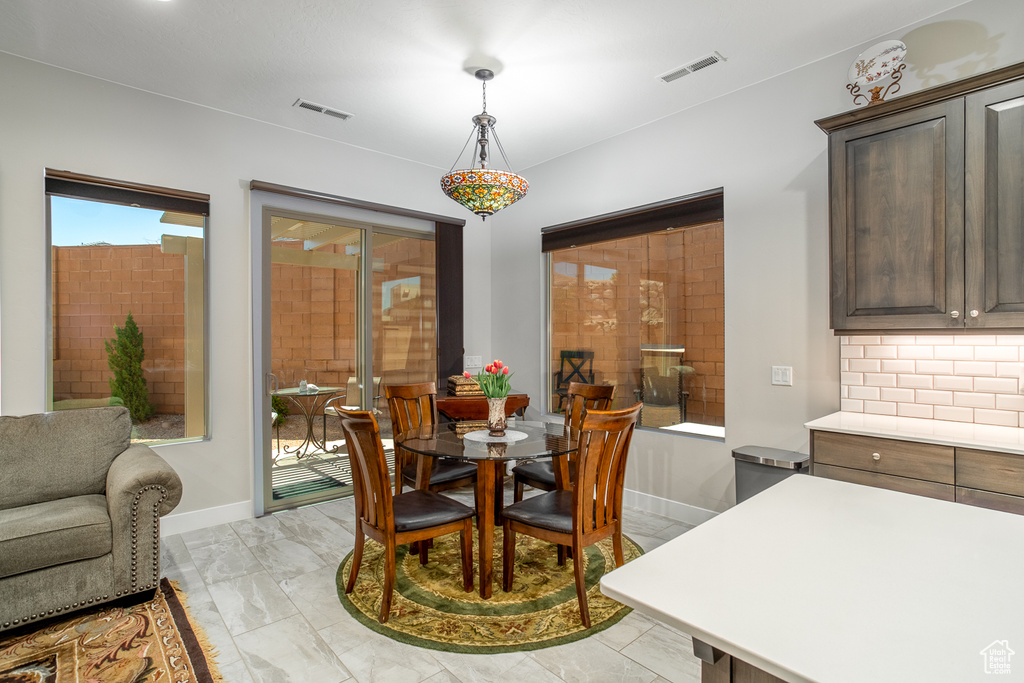 Dining area featuring visible vents, marble finish floor, and baseboards