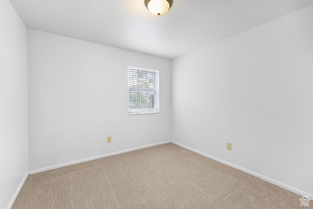 Empty room featuring baseboards and carpet