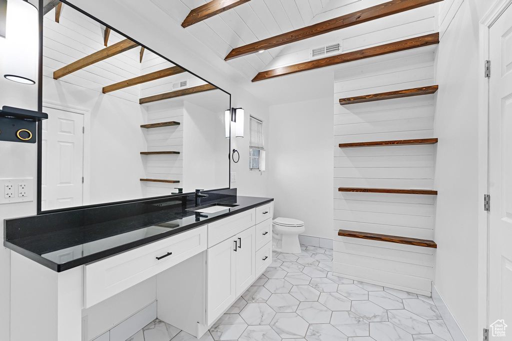 Bathroom with vanity, beamed ceiling, toilet, and visible vents