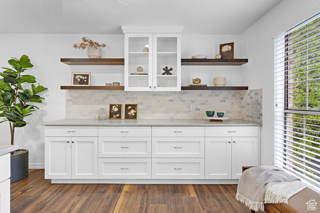 Bar with tasteful backsplash and dark wood-style floors
