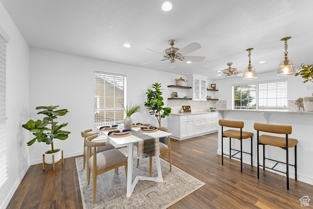 Dining room with baseboards, dark wood-style flooring, a ceiling fan, and recessed lighting