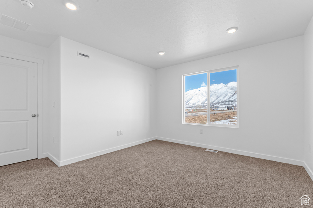 Carpeted empty room featuring recessed lighting, baseboards, and visible vents