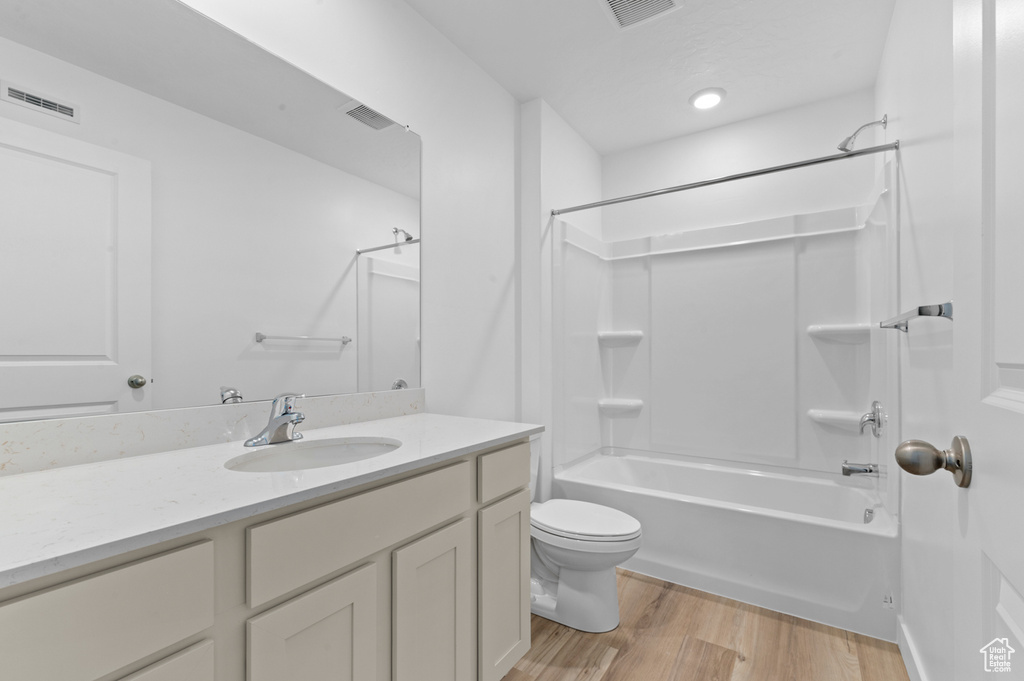 Bathroom featuring visible vents, wood finished floors, toilet, and vanity