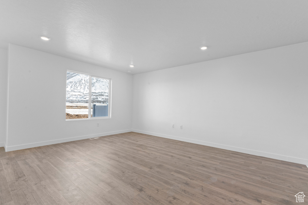 Spare room featuring recessed lighting, baseboards, and light wood-style floors