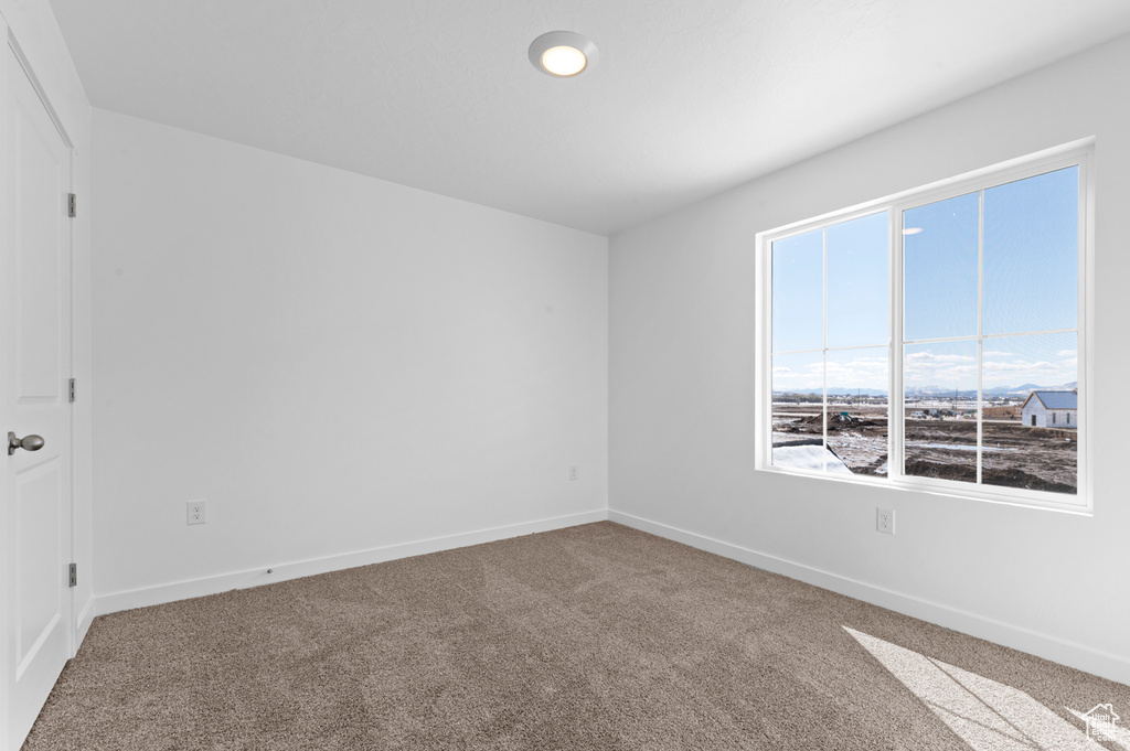 Carpeted empty room with baseboards