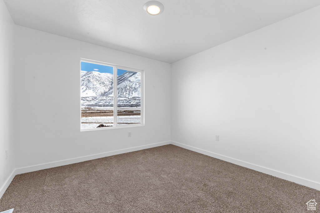 Spare room featuring baseboards and carpet