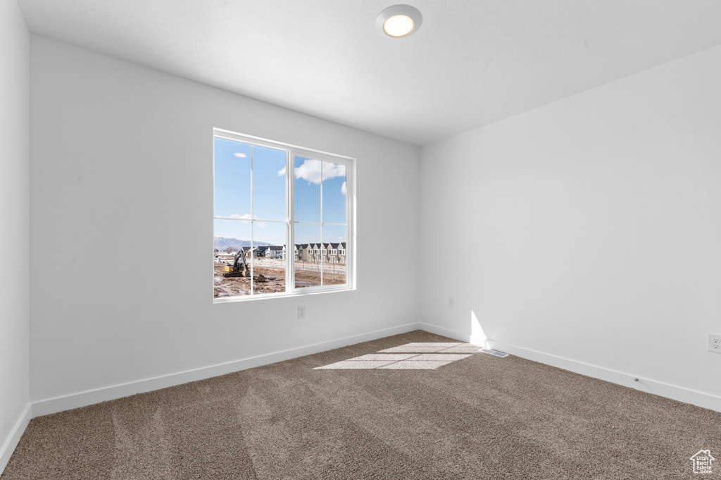 Unfurnished room featuring carpet floors and baseboards