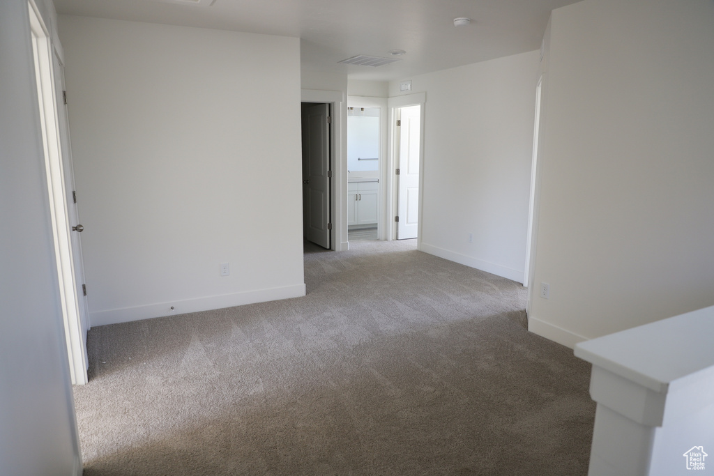 Spare room featuring baseboards, carpet flooring, and visible vents