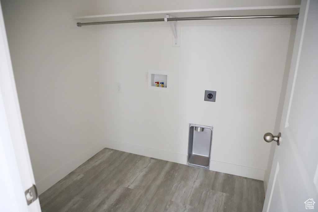 Washroom featuring washer hookup, hookup for an electric dryer, laundry area, wood finished floors, and baseboards
