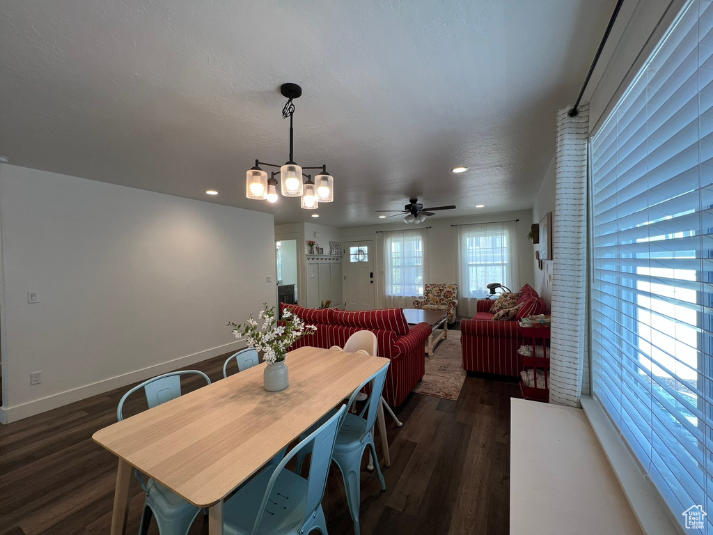 Dining area featuring baseboards, ceiling fan with notable chandelier, recessed lighting, and dark wood-type flooring