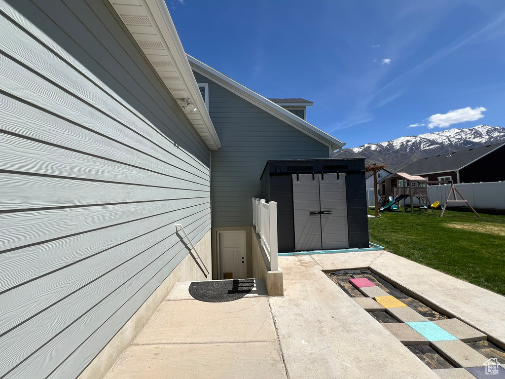 View of patio / terrace with fence, a mountain view, and a playground