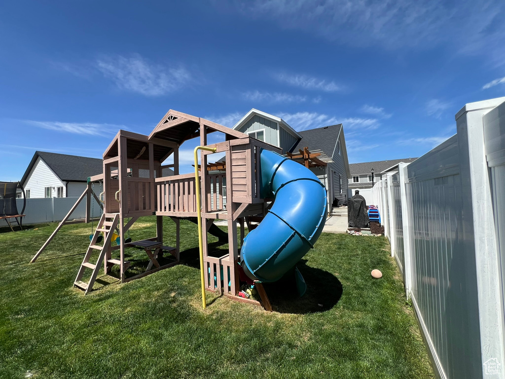 View of jungle gym with a fenced backyard and a yard