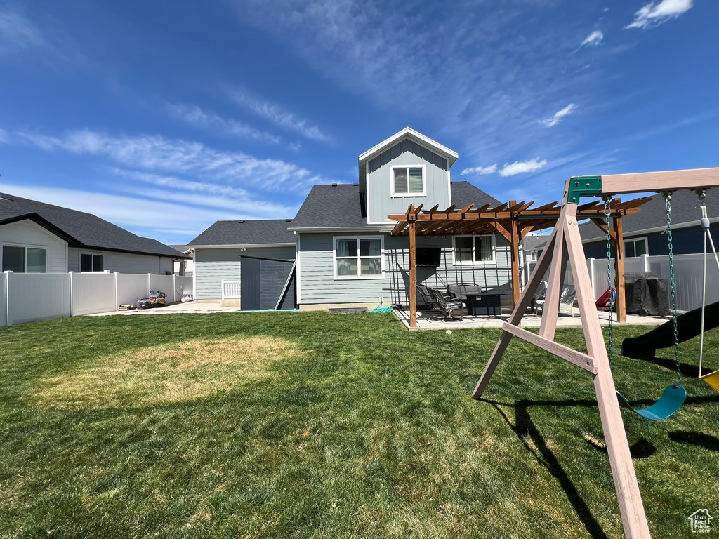 Rear view of property featuring a yard, a patio, a fenced backyard, and a pergola