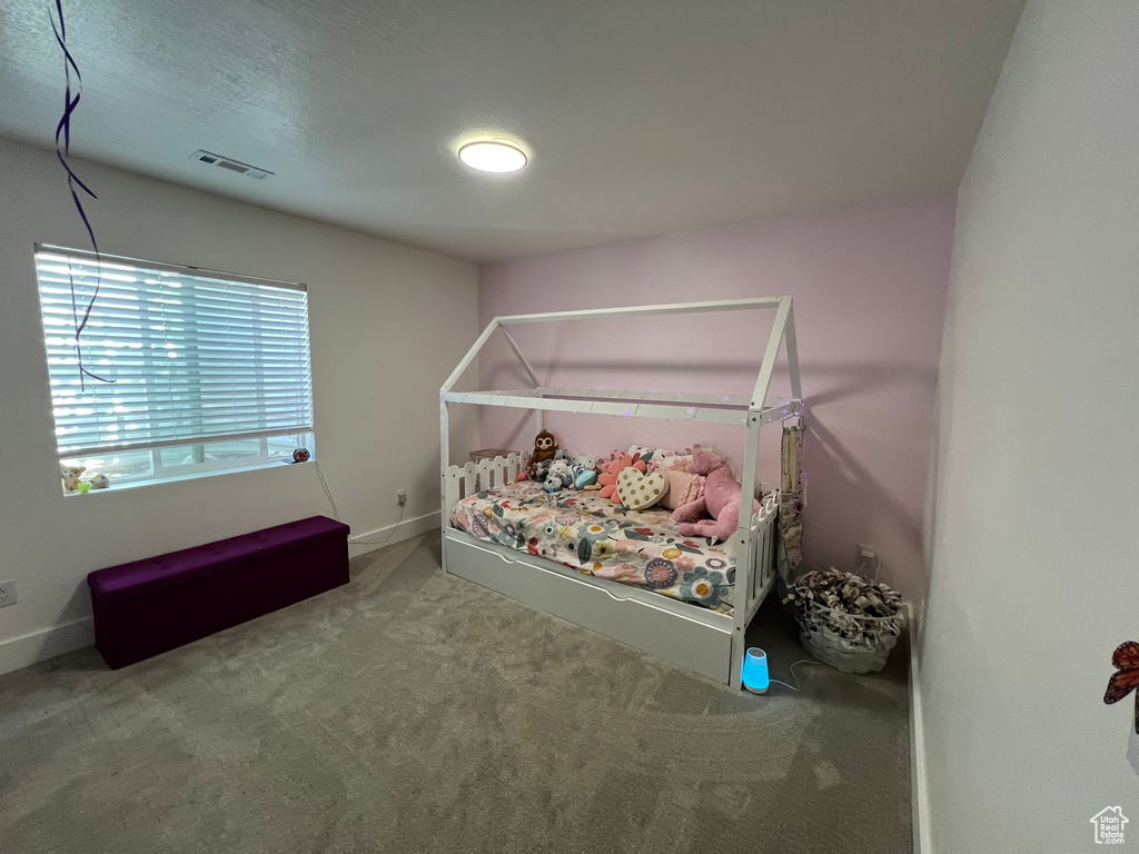 Bedroom with carpet floors, baseboards, and visible vents