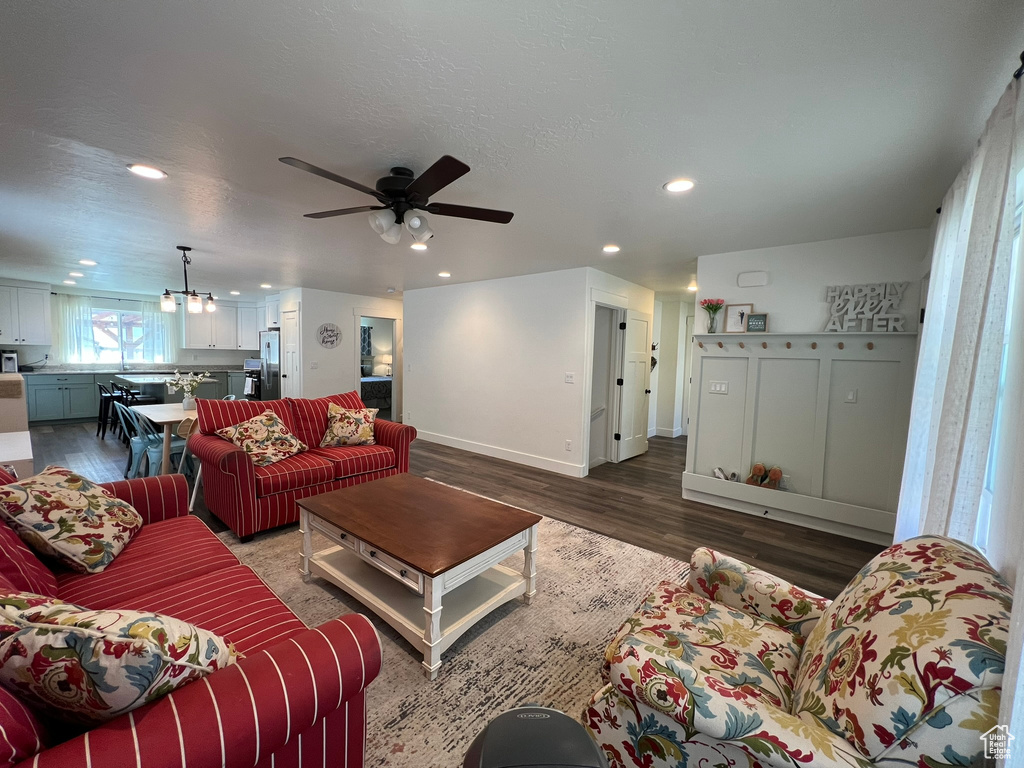 Living area with recessed lighting, baseboards, ceiling fan with notable chandelier, and wood finished floors