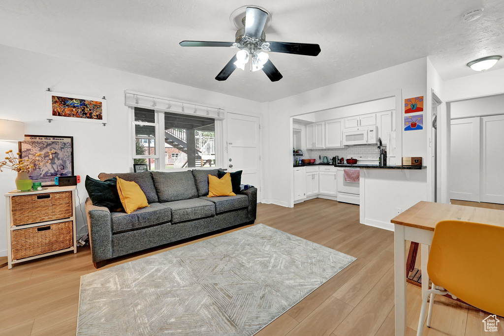 Living room featuring ceiling fan and light wood finished floors