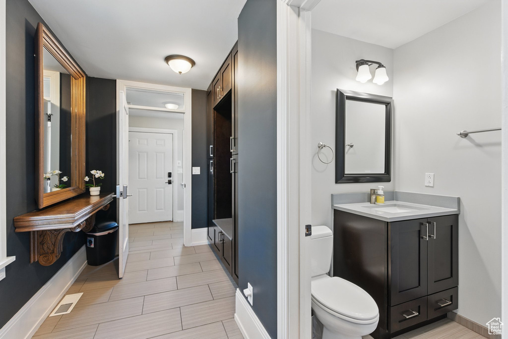 Bathroom featuring vanity, baseboards, and toilet