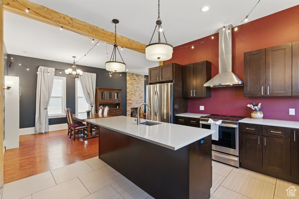 Kitchen with light countertops, a sink, extractor fan, and stainless steel appliances