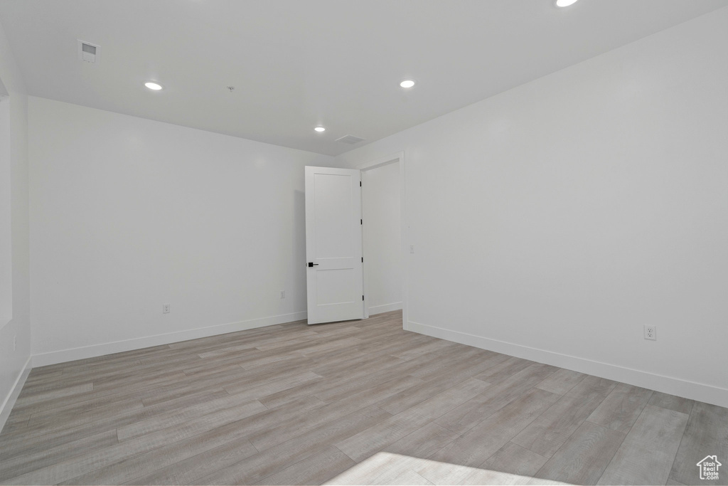 Empty room with light wood-type flooring, recessed lighting, and baseboards