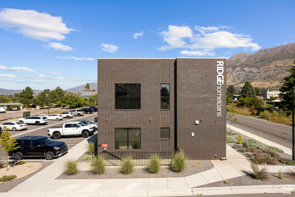 View of property exterior with uncovered parking and a mountain view