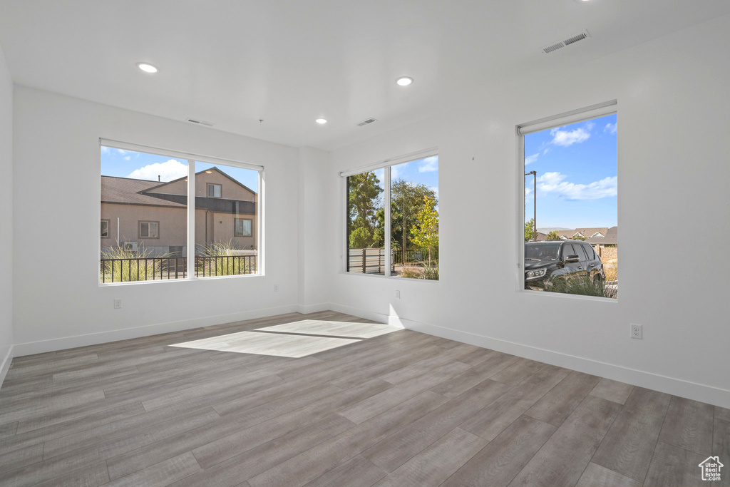 Unfurnished room featuring baseboards, recessed lighting, wood finished floors, and visible vents