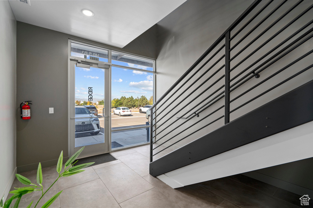 Interior space with baseboards, recessed lighting, stairs, and tile patterned floors
