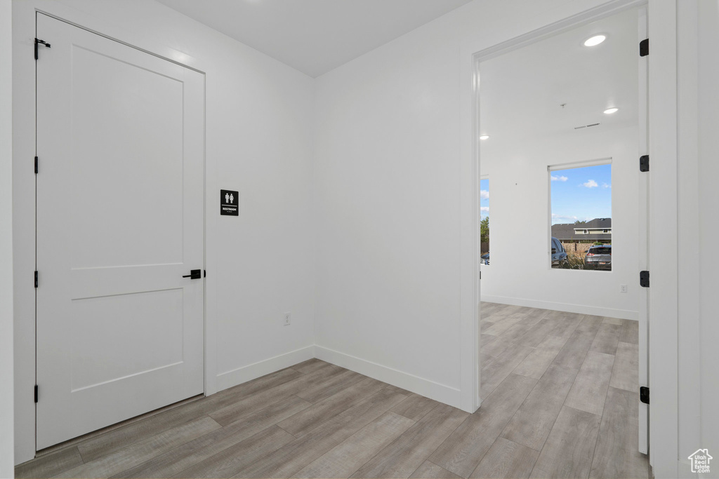 Hall with baseboards, recessed lighting, and light wood-style flooring