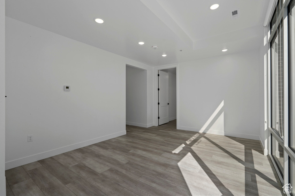Spare room featuring baseboards, recessed lighting, wood finished floors, and visible vents