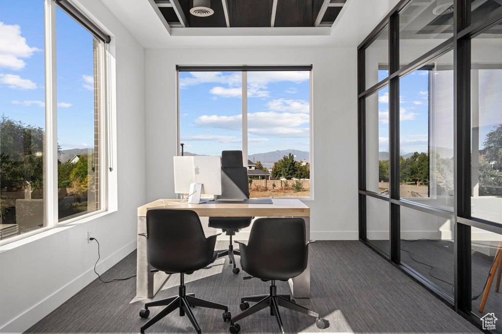 Home office with baseboards, a mountain view, and dark colored carpet