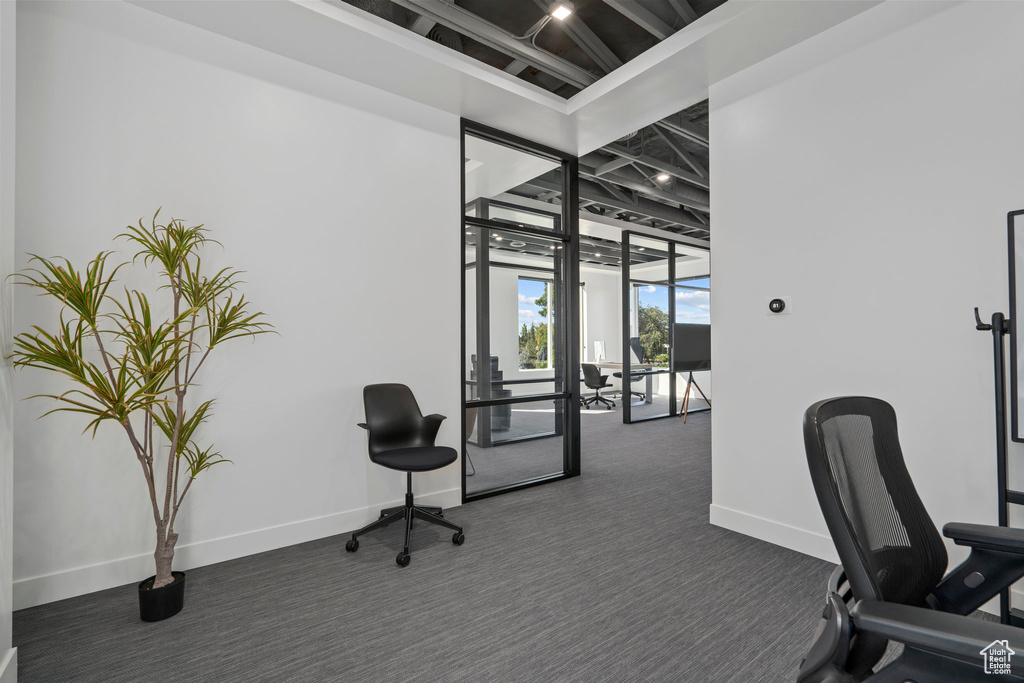 Home office featuring baseboards and dark colored carpet