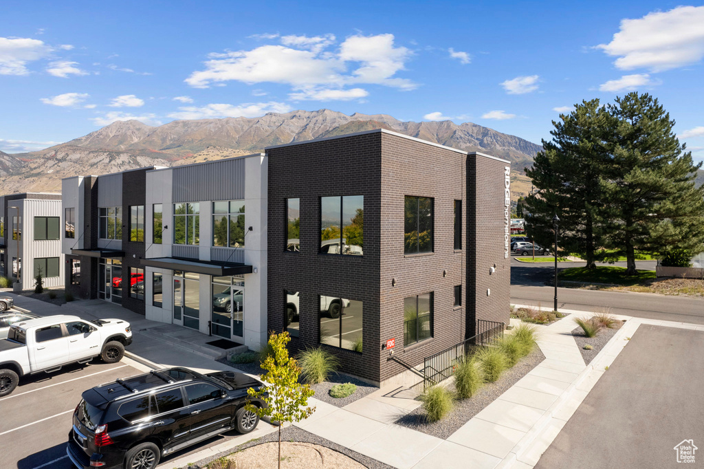 View of property with a mountain view and uncovered parking