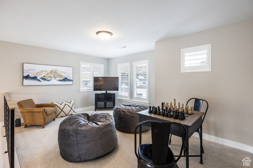 Carpeted living room featuring a wealth of natural light, baseboards, and visible vents