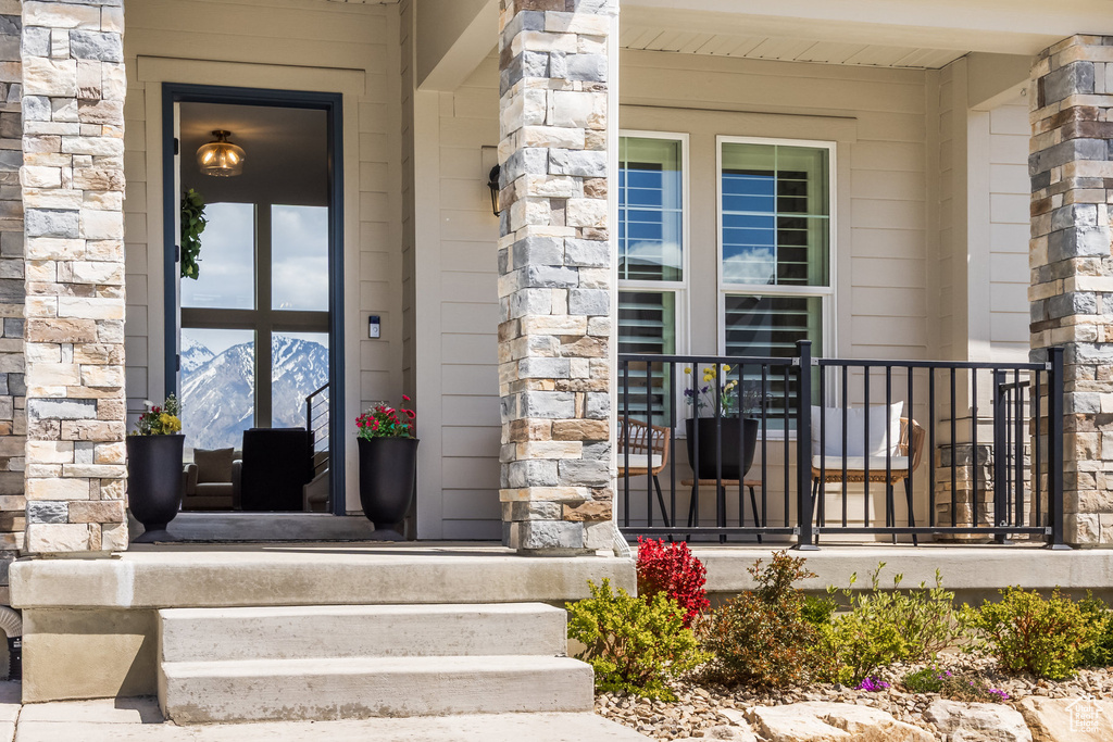 Doorway to property featuring covered porch and stone siding