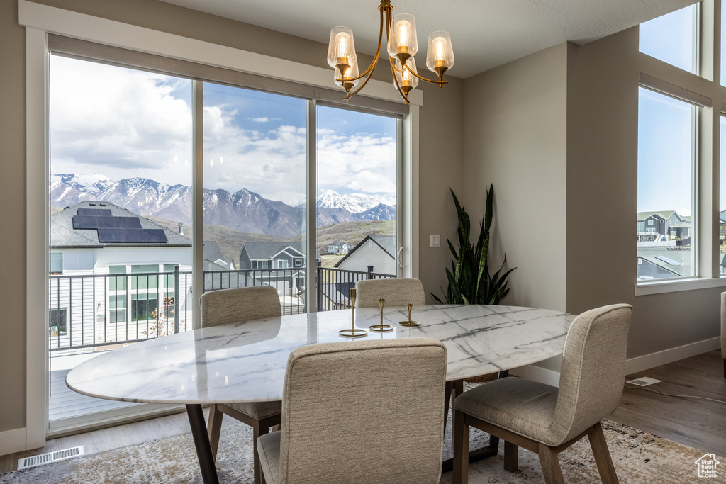 Dining room with a mountain view, plenty of natural light, a chandelier, and visible vents