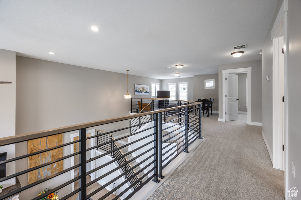 Corridor featuring recessed lighting, baseboards, carpet flooring, visible vents, and an upstairs landing