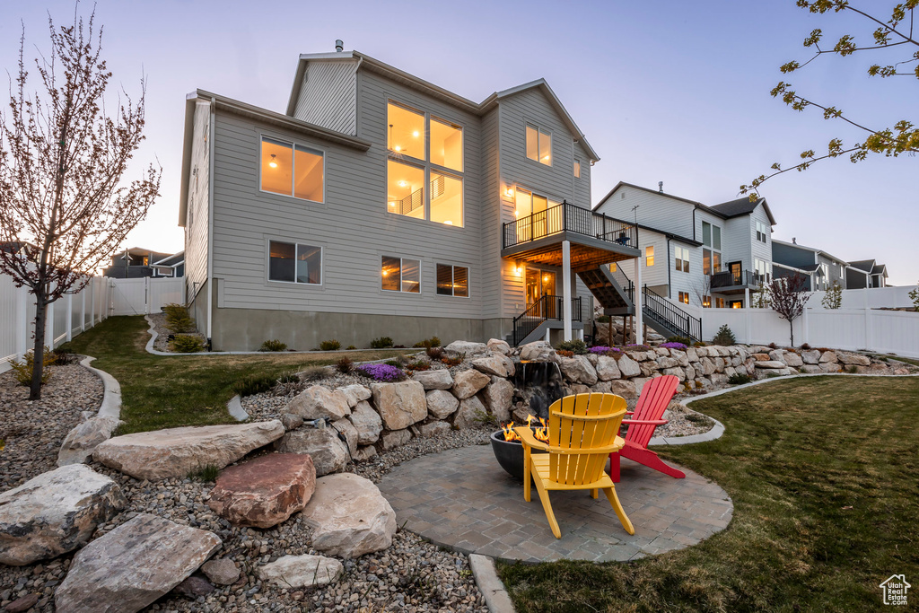 Back of house with a patio, a fenced backyard, a balcony, a yard, and stairs