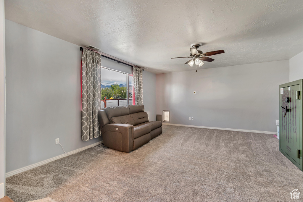 Sitting room with carpet floors, a ceiling fan, and a textured ceiling