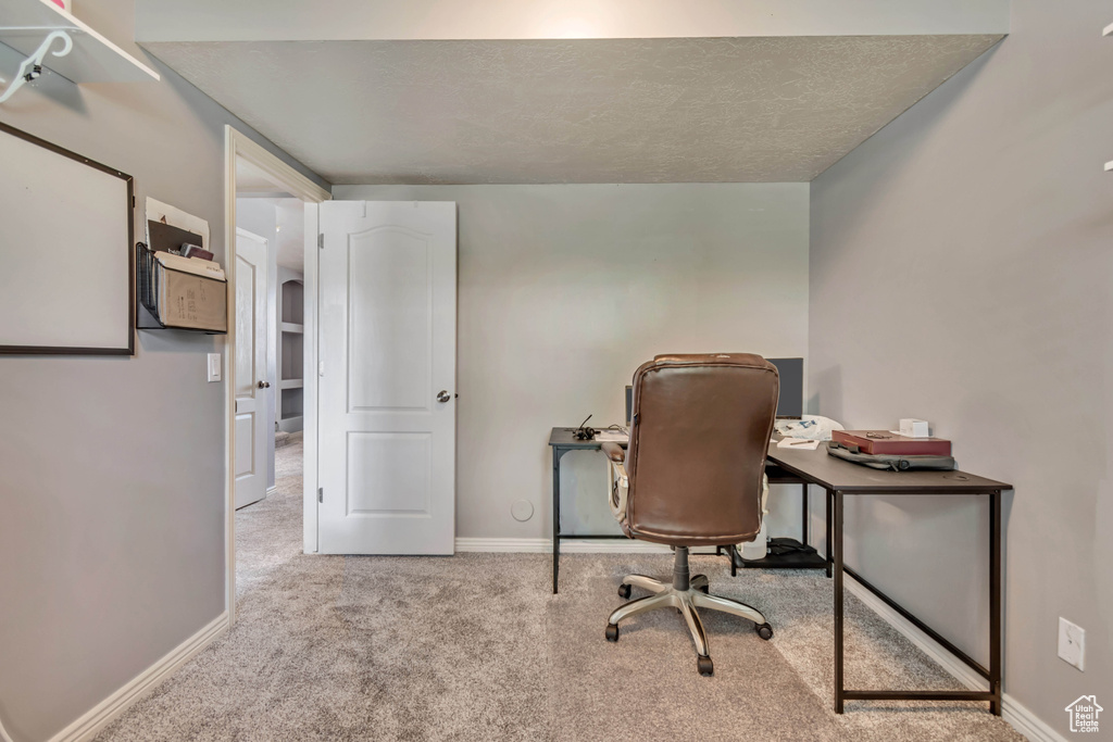 Home office with baseboards and carpet