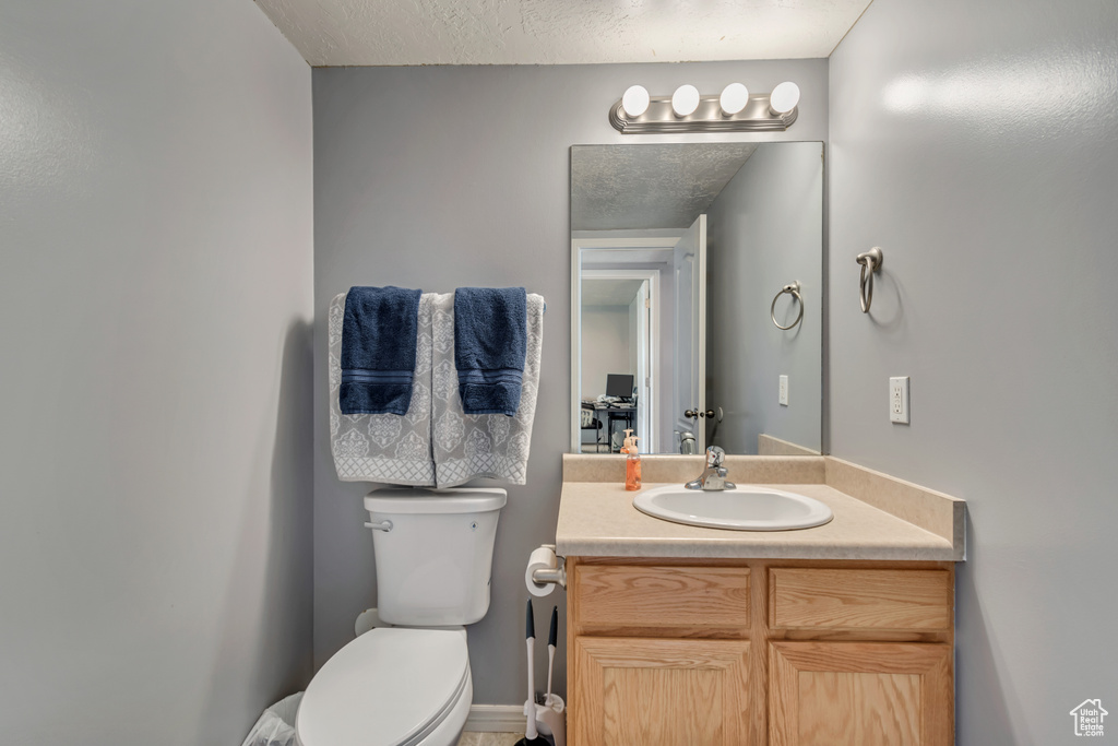 Half bathroom featuring vanity and toilet