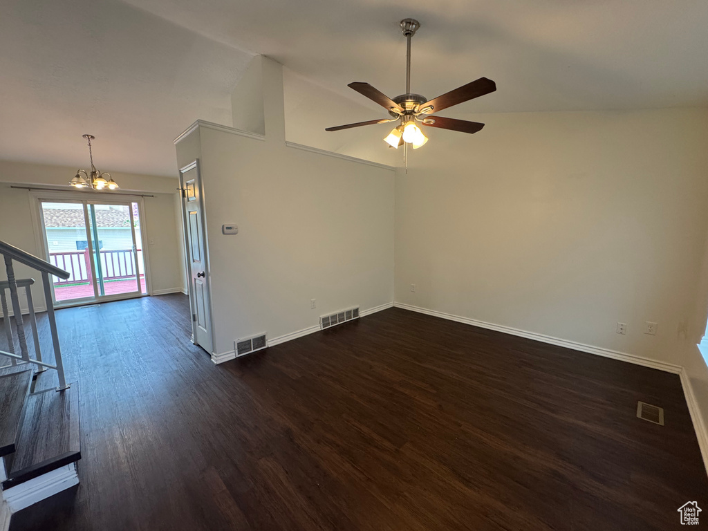 Unfurnished room featuring visible vents, dark wood finished floors, and ceiling fan with notable chandelier