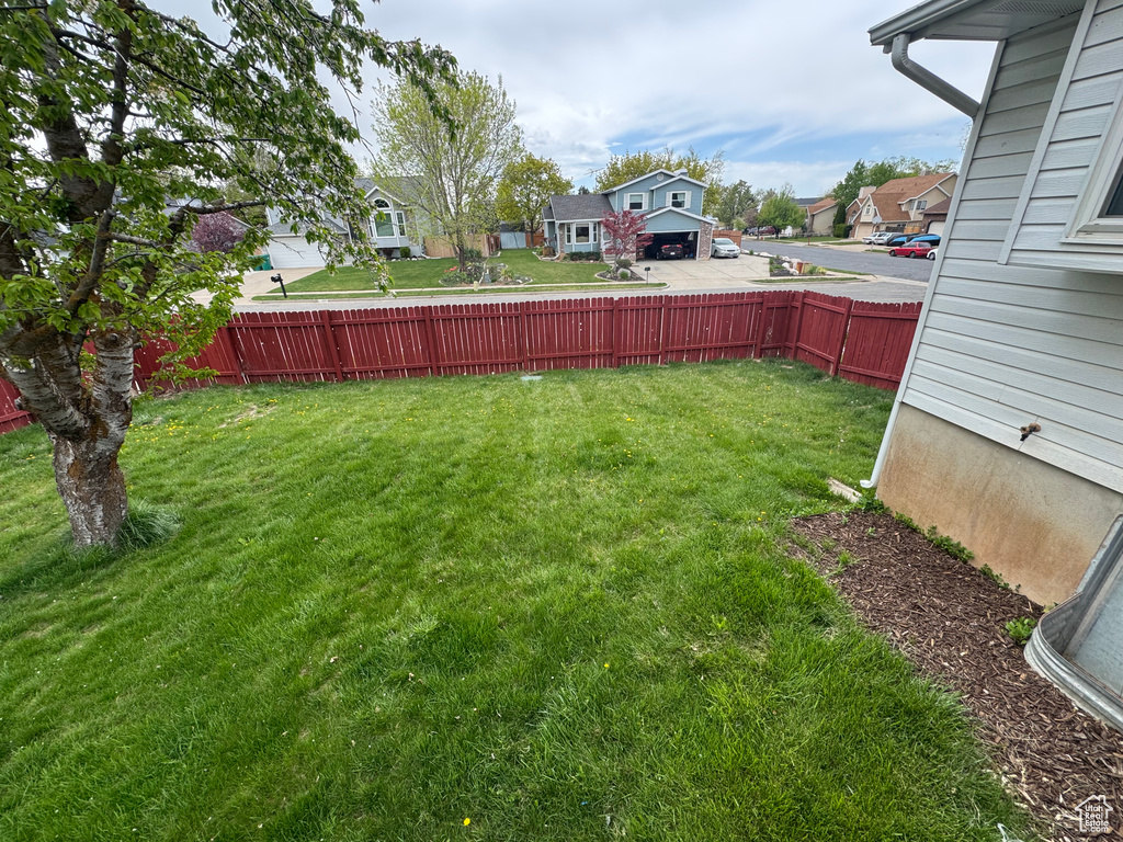 View of yard with a residential view and fence
