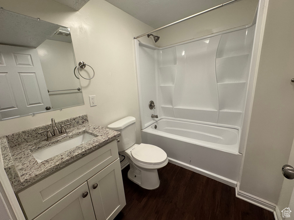 Bathroom featuring vanity, shower / tub combination, wood finished floors, and toilet