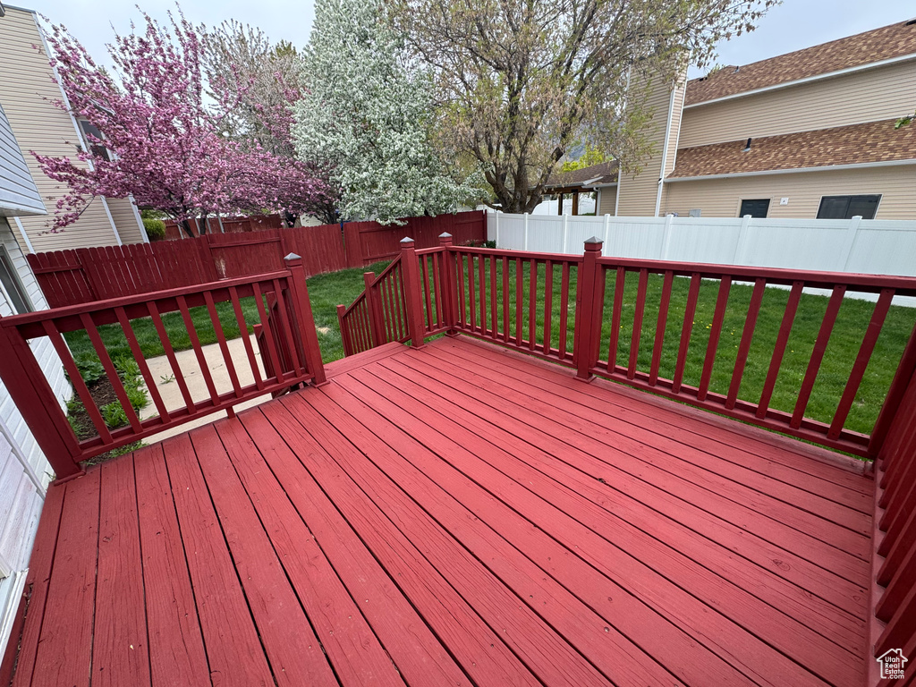 Wooden terrace with a fenced backyard and a yard
