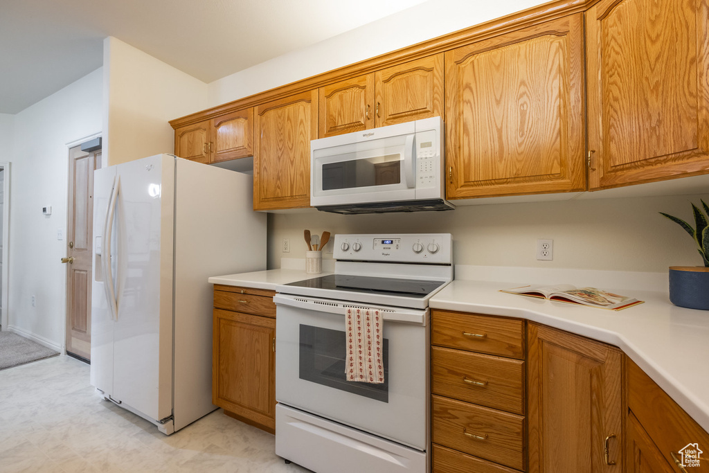 Kitchen with brown cabinets and white appliances