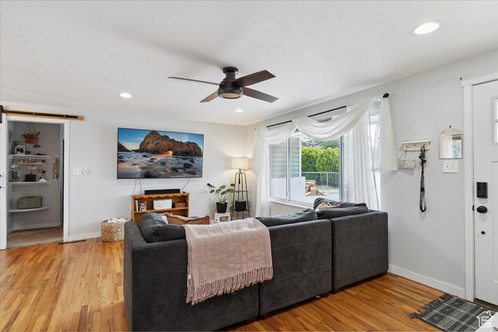 Living room featuring baseboards, ceiling fan, and wood finished floors
