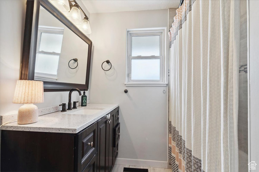 Bathroom featuring a healthy amount of sunlight, baseboards, and vanity